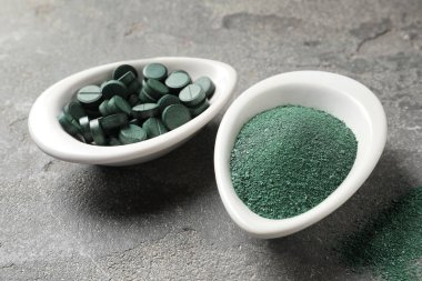 Spirulina hapları ve renk arka plan, closeup üzerinde toz yemekleri