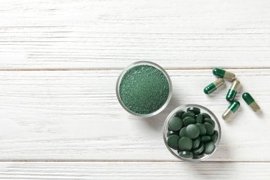 Spirulina hapları ve ahşap arka plan, üstten görünüm üzerinde toz kase. Metin için yer