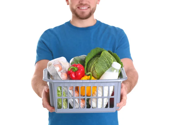 Entrega hombre sosteniendo caja de plástico con productos alimenticios sobre fondo blanco, primer plano —  Fotos de Stock