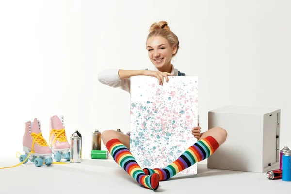 Женщина с винтажными роликами, баллончиками с краской и красивой картиной на белом фоне — стоковое фото