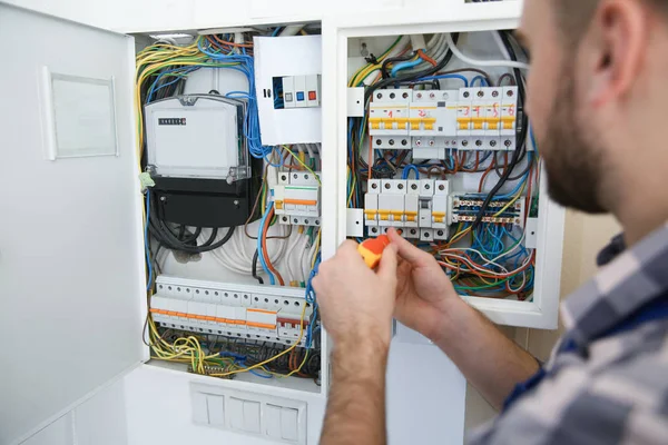 Electricista reparando caja de fusibles con destornillador interior, primer plano —  Fotos de Stock