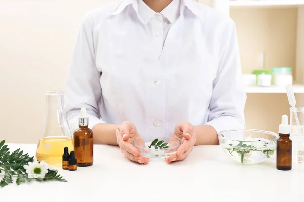 Dermatóloga femenina creando productos para el cuidado de la piel en la mesa, primer plano — Foto de Stock