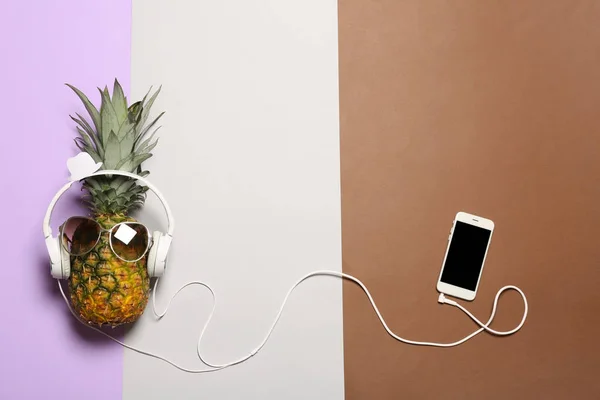 Funny pineapple with headphones, smartphone and sunglasses on color background, flat lay. Space for text — Stock Photo, Image