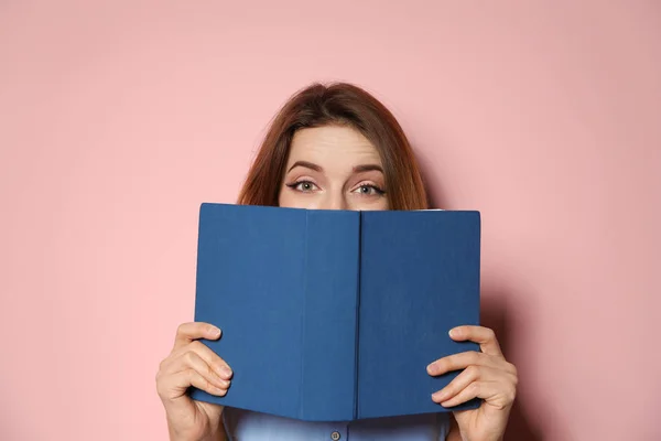 Young woman with book on color background — Stock Photo, Image