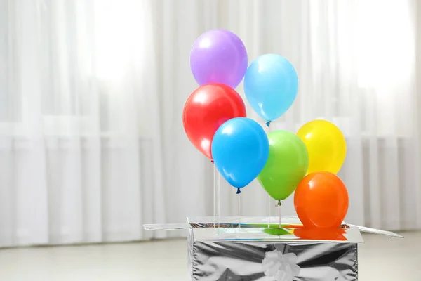 Caja de regalo con globos de aire brillante en el interior. Espacio para texto — Foto de Stock