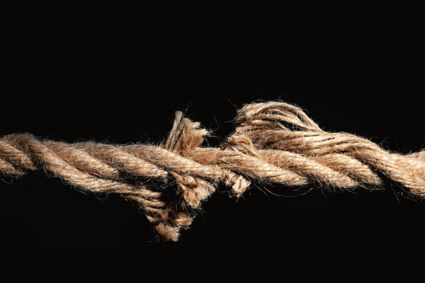 Разрыв хлопчатобумажной веревки на черном фоне
