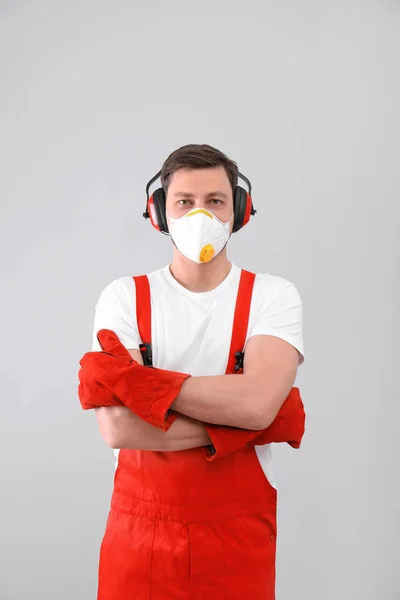 Trabajador industrial masculino en uniforme sobre fondo claro. Equipo de seguridad —  Fotos de Stock