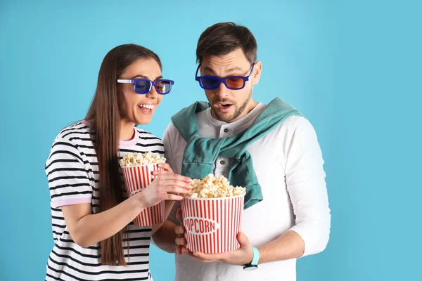 Junge Frau klaut Popcorn von Freund auf farbigem Hintergrund — Stockfoto