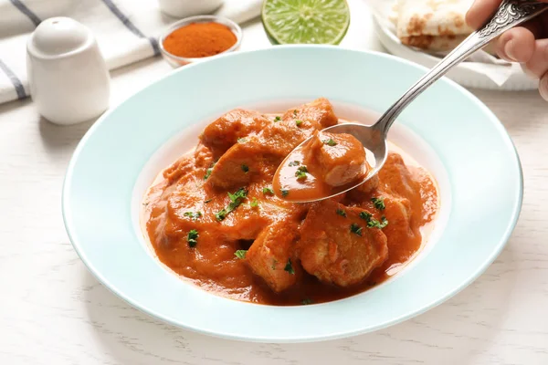 Donna che mangia gustoso pollo al burro a tavola, primo piano. Piatto tradizionale Murgh Makhani — Foto Stock