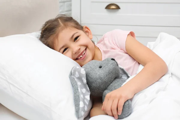Cute child with stuffed rabbit resting in bed at hospital — Stock Photo, Image