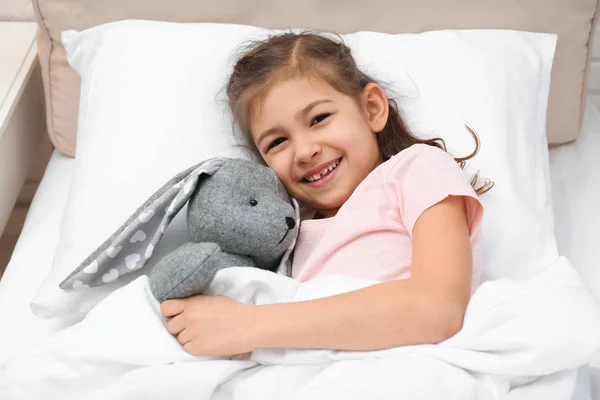 Enfant mignon avec lapin farci se reposant au lit à l'hôpital — Photo