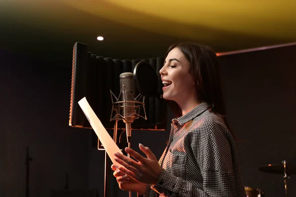 Νεαρή τραγουδίστρια με μικρόφωνο καταγράφει το τραγούδι στο studio — Φωτογραφία Αρχείου