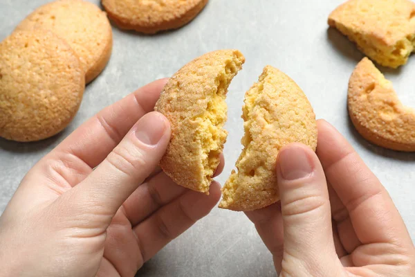 Mujer sosteniendo galletas de mantequilla danesa rotas por encima de la mesa, primer plano — Foto de Stock