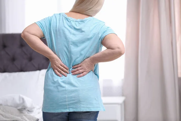 Senior vrouw lijden aan rugpijn thuis, close-up — Stockfoto