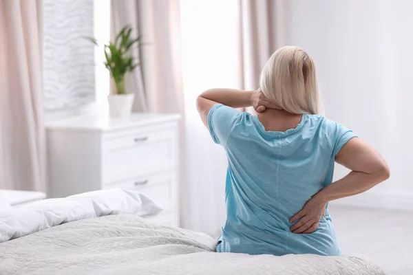 Mulher Sênior sofrendo de dor nas costas em casa — Fotografia de Stock