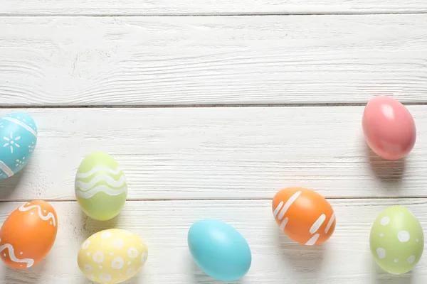 Composición plana de huevos de Pascua pintados sobre fondo de madera, espacio para texto — Foto de Stock