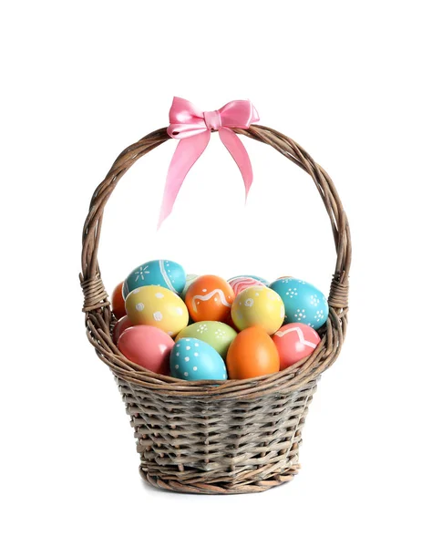 Wicker basket with painted Easter eggs on white background — Stock Photo, Image