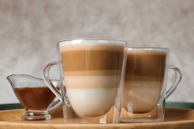 Karamel macchiato ve tablo teknede et suyu şurubu cam bardak ile tepsi