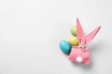 Paskalya tavşanı hediye çanta ve boyalı yumurta beyaz arka planda, üstten görünüm