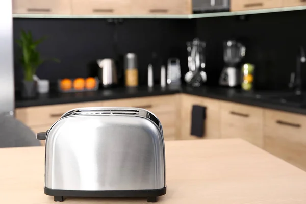 Modern toaster on table in kitchen, selective focus