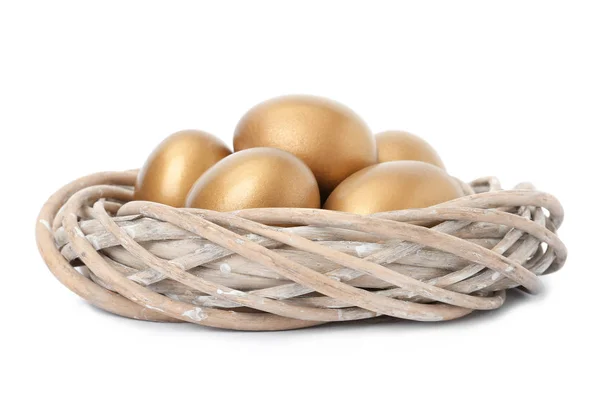 Золотые яйца в гнезде на белом фоне — стоковое фото