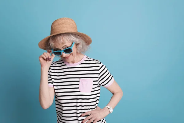 Porträtt av mogen kvinna i hipster outfit på färgbakgrund. Utrymme för text — Stockfoto