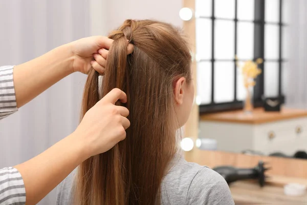 Profissional coiffeuse trançar o cabelo do cliente no salão — Fotografia de Stock