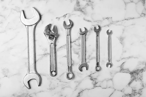 Νέα κλειδιά σε μαρμάρινο φόντο, το top view. Εργαλεία για υδραυλικούς — Φωτογραφία Αρχείου