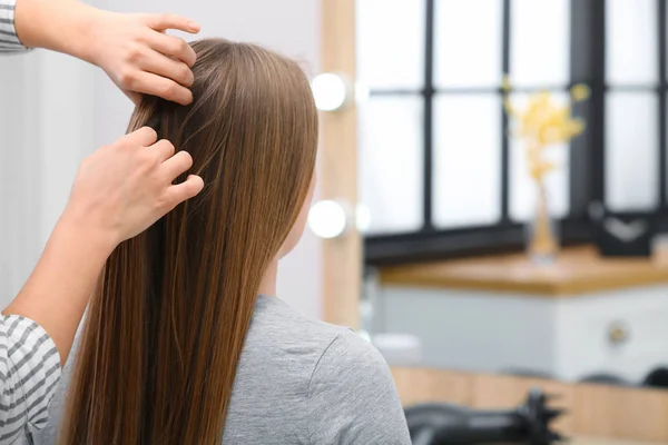 Professional coiffeuse braiding client's hair in salon — Stock Photo, Image