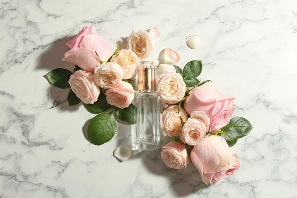 Belle composition avec bouteille de parfum et roses sur fond de marbre, vue de dessus — Photo