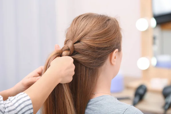 Professional coiffeuse braiding client's hair in salon — Stock Photo, Image