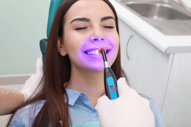 Modern klinik, closeup hastada ile çalışan profesyonel diş hekimi. Diş beyazlatma