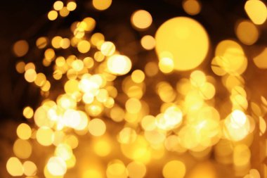 Koyu arka plan üzerinde bokeh etkisi ile altın glitter