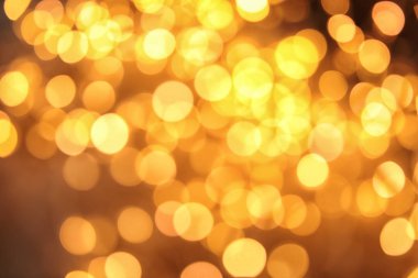 Koyu arka plan üzerinde bokeh etkisi ile altın glitter