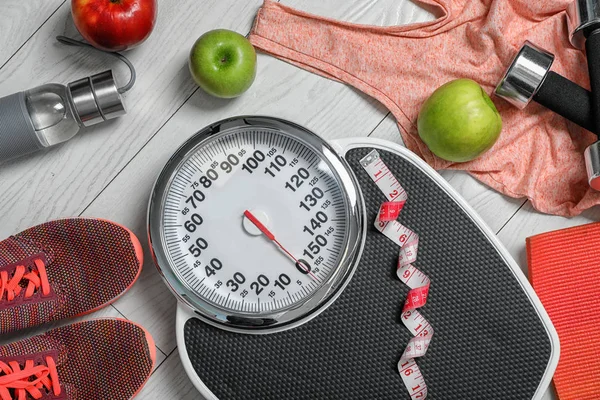 Flat lay composition with scales, apples and sport equipment on wooden background. Weight loss — Stock Photo, Image