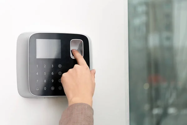 Woman scanning fingerprint on alarm system indoors, closeup. Space for text — Stock Photo, Image