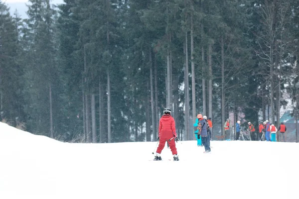 Menschen rutschen am Hang im Skigebiet. Winterurlaub — Stockfoto