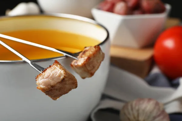 Panela de fondue e garfos com carne cozida na mesa, close-up — Fotografia de Stock