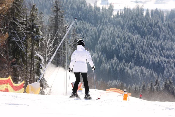 Vrouw skiën op de besneeuwde heuvel in bergen. Wintervakantie — Stockfoto