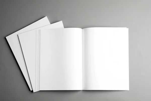 Folhetos em branco abertos e fechados sobre fundo cinza, vista superior. Mock up para o projeto — Fotografia de Stock