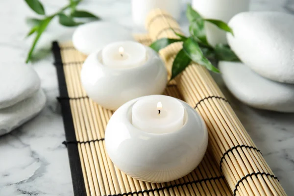 Hermosa composición de spa con velas y estera de bambú sobre fondo de mármol —  Fotos de Stock