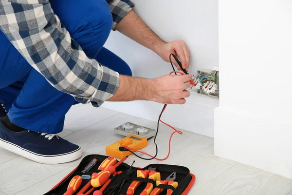 Electricista con voltaje de comprobación del probador en interiores, primer plano — Foto de Stock