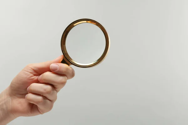 Mujer sosteniendo lupa sobre fondo blanco, primer plano. Espacio para texto —  Fotos de Stock