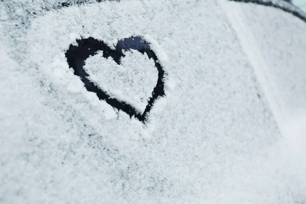 Heart drawn on car covered with snow, closeup. Space for text