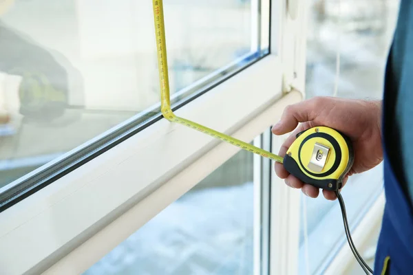 Service man meten venster voor installatie binnenshuis, close-up — Stockfoto