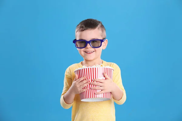 Mignon petit garçon avec pop-corn et lunettes sur fond de couleur — Photo