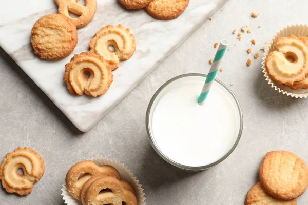 Composición plana con galletas de mantequilla danesa y vaso de leche sobre fondo gris — Foto de Stock