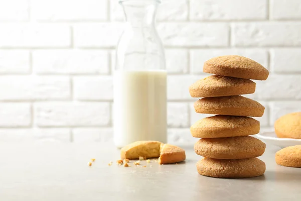 Montón de galletas de mantequilla danesa y leche en la mesa contra la pared de ladrillo. Espacio para texto — Foto de Stock