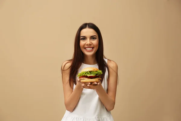 背景色でおいしいハンバーガーを持つ若い女性 — ストック写真