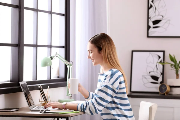 Tonårig flicka använder laptop vid bord i hennes rum — Stockfoto